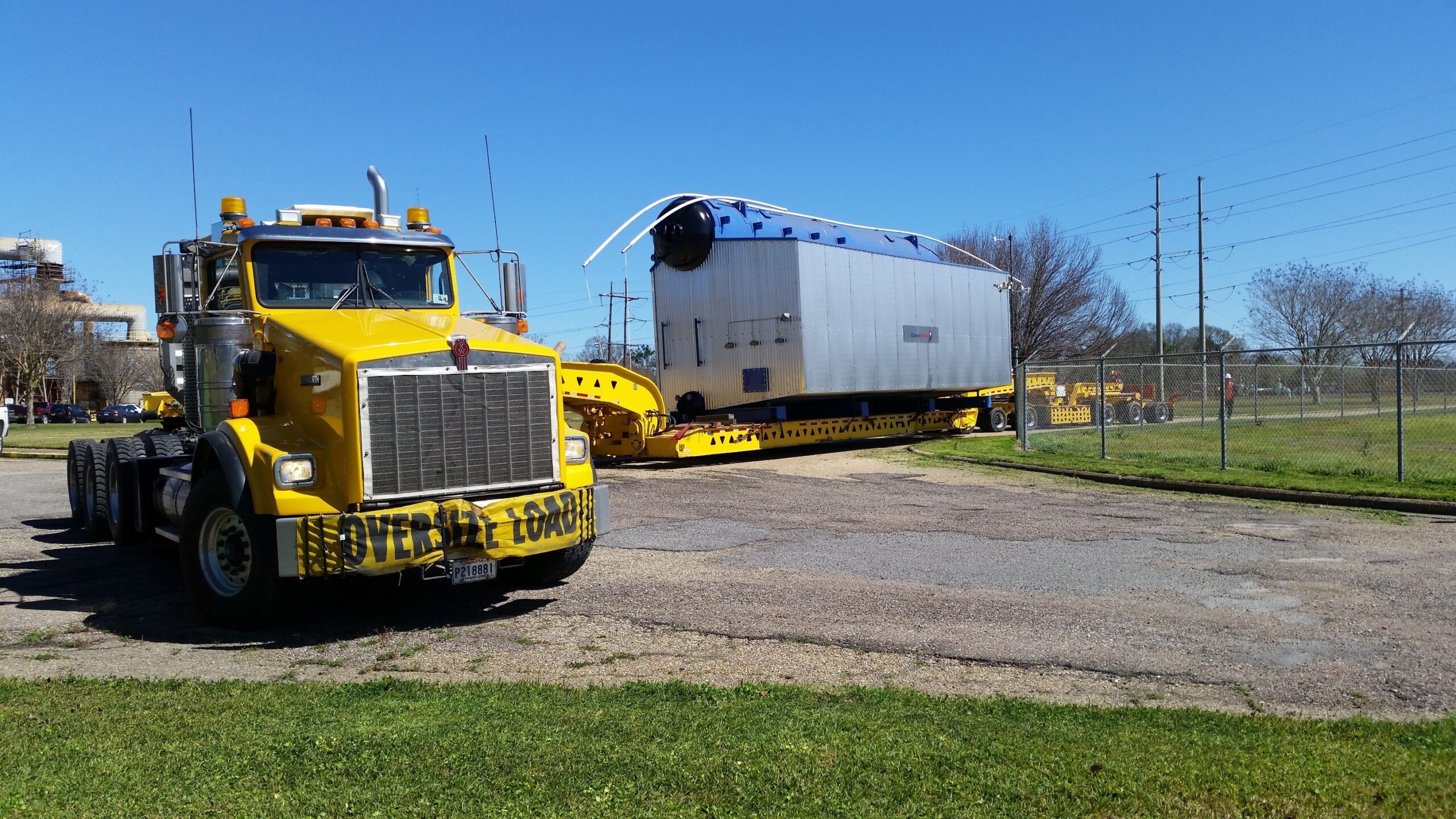 H. Brown, Inc. heavy hauling service making a tight turn into a plant with a boiler.