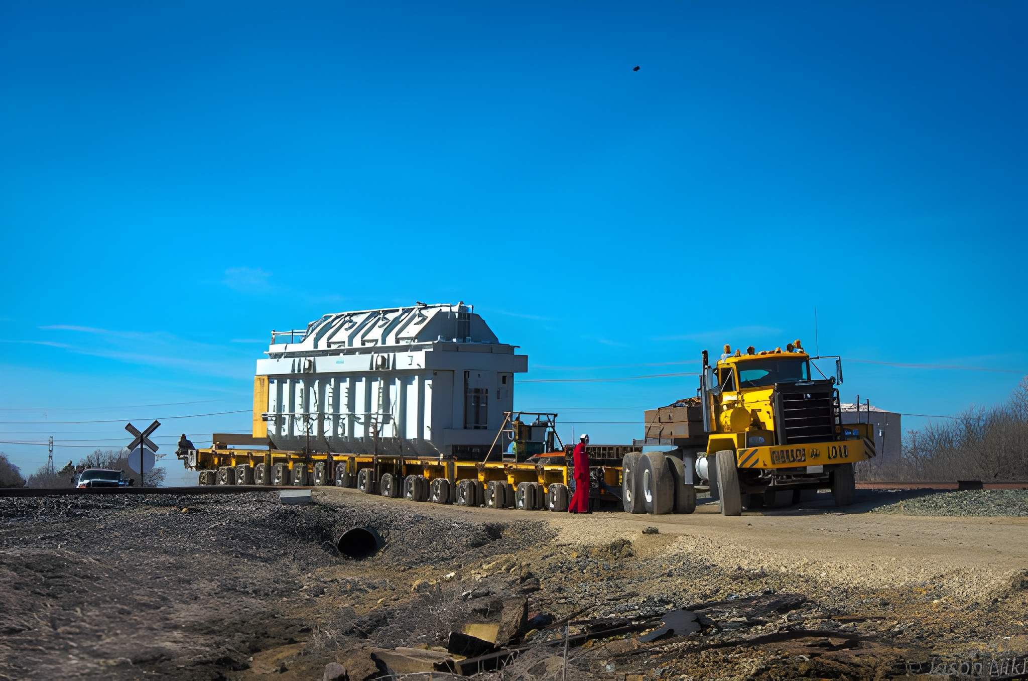 H. Brown, Inc. specialized transportation service crossing railroad tracks with a large transformer using SPMTs.